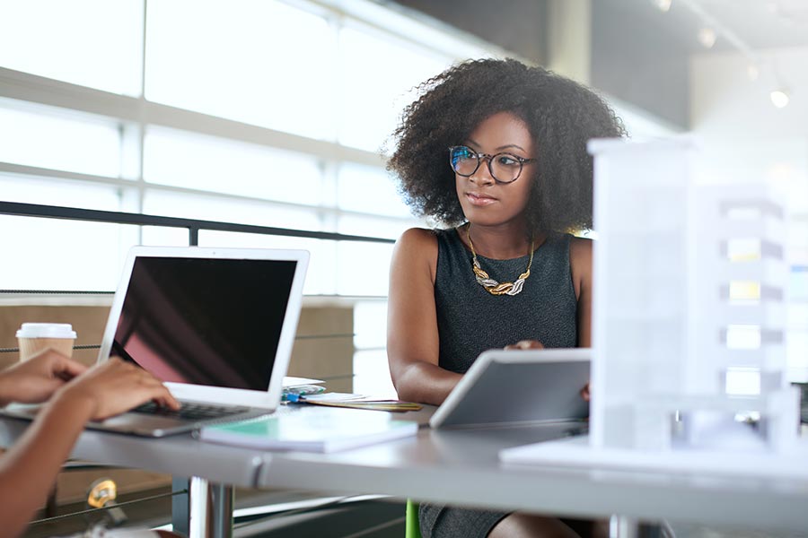 A woman wearing black and working at a desk.