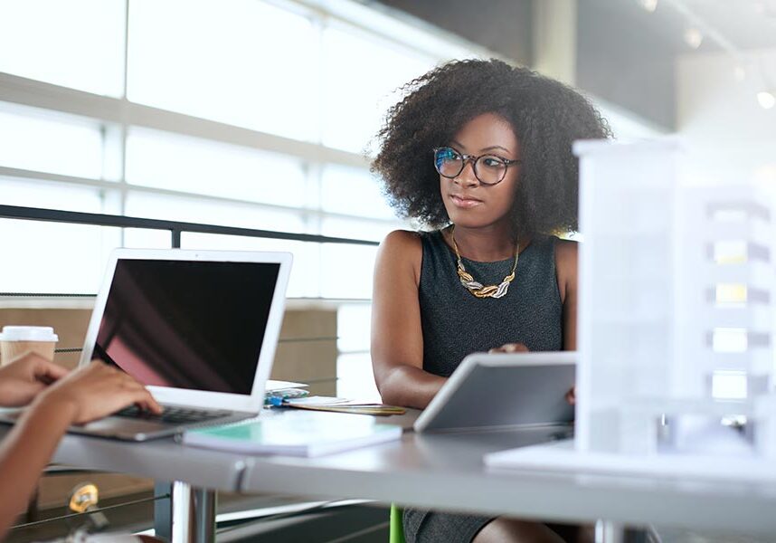 A woman wearing black and working at a desk.